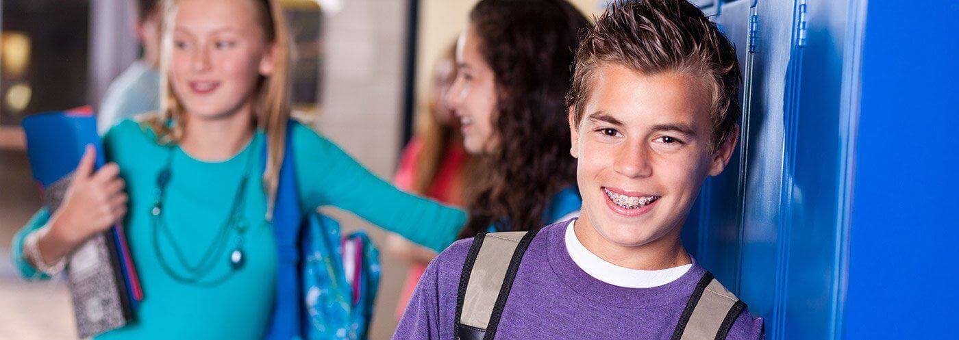 Teen boy with braces at school